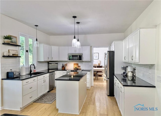 2456 Wembley Ter, Toledo, OH 43617 - kitchen featuring appliances with stainless steel finishes, dark countertops, decorative backsplash, and a kitchen island