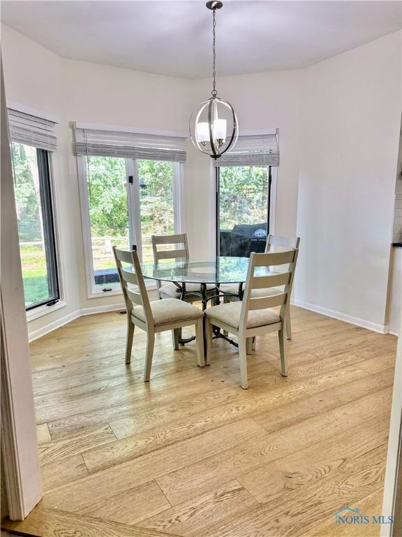 2456 Wembley Ter, Toledo, OH 43617 - dining space featuring a chandelier, light wood-style floors, and healthy amount of natural light