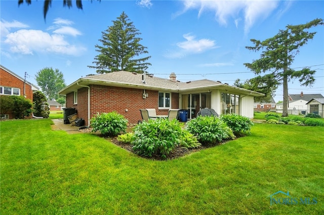 2519 Melva Ct, Toledo, OH 43611 - rear view of house featuring brick siding and a yard