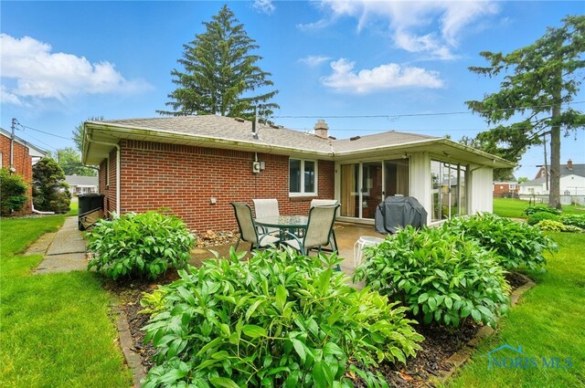 2519 Melva Ct, Toledo, OH 43611 - back of house featuring brick siding, a patio, and a yard