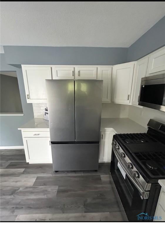 2509 Orchard Hills Blvd, Toledo, OH 43615 - kitchen featuring appliances with stainless steel finishes, white cabinets, light countertops, and dark wood finished floors