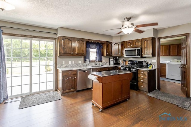 5226 Summer Dr, Sylvania, OH 43560 - kitchen with stainless steel appliances, a ceiling fan, a textured ceiling, independent washer and dryer, and dark wood-type flooring