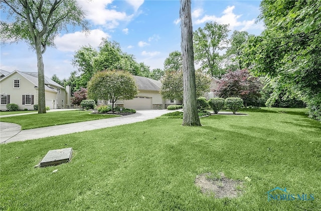 4068 Deer Ravine Ct, Maumee, OH 43537 - view of grassy yard featuring a garage and concrete driveway