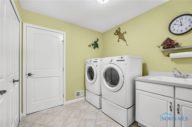 4068 Deer Ravine Ct, Maumee, OH 43537 - laundry room featuring washing machine and dryer, cabinet space, and light tile patterned floors