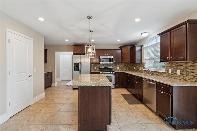 4382 Morgan Pl, Perrysburg, OH 43551 - kitchen with appliances with stainless steel finishes, tasteful backsplash, dark brown cabinets, light stone counters, and a kitchen island