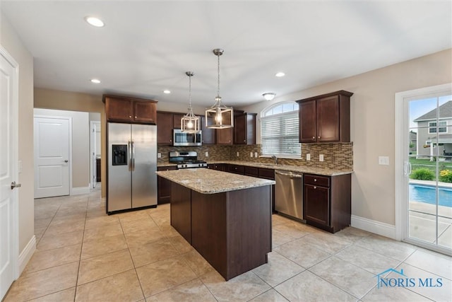 4382 Morgan Pl, Perrysburg, OH 43551 - kitchen with appliances with stainless steel finishes, dark brown cabinetry, tasteful backsplash, a kitchen island, and recessed lighting