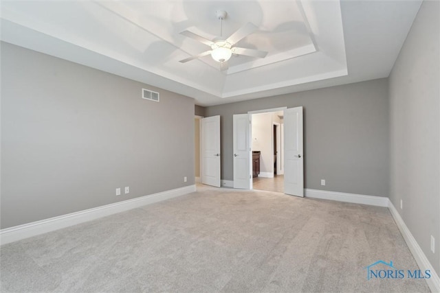 4382 Morgan Pl, Perrysburg, OH 43551 - unfurnished bedroom with a tray ceiling, light colored carpet, ensuite bath, and a ceiling fan