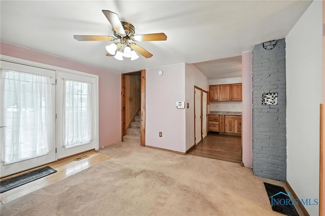 356 S Belmore St, Leipsic, OH 45856 - unfurnished living room with ceiling fan, light carpet, and stairs