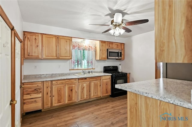 356 S Belmore St, Leipsic, OH 45856 - kitchen with gas stove, stainless steel microwave, light wood-style floors, and ceiling fan