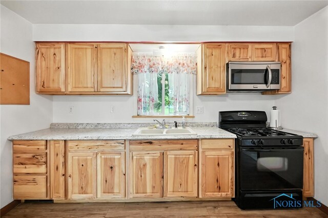356 S Belmore St, Leipsic, OH 45856 - kitchen featuring stainless steel microwave, black gas range oven, light wood finished floors, and light brown cabinetry