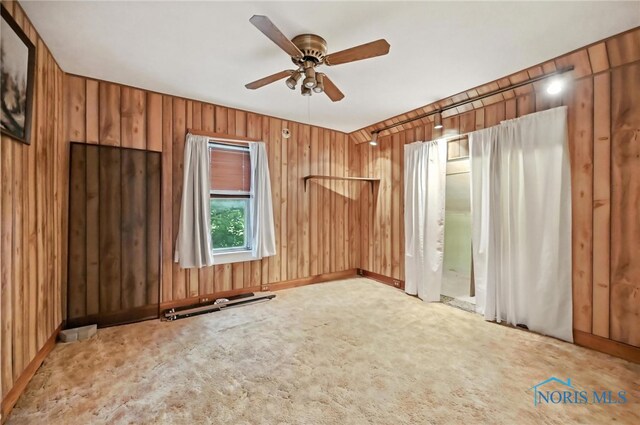356 S Belmore St, Leipsic, OH 45856 - spare room featuring ceiling fan, carpet floors, and wood walls