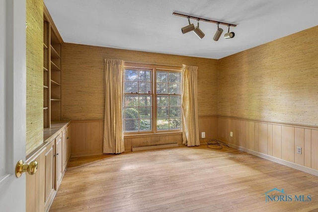 3432 Corey Rd, Toledo, OH 43615 - unfurnished room with a baseboard radiator, light wood-type flooring, a wainscoted wall, rail lighting, and wallpapered walls