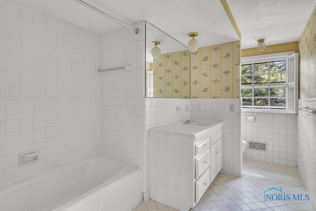 3432 Corey Rd, Toledo, OH 43615 - full bathroom featuring tile walls, wallpapered walls, tile patterned floors, a tub, and vanity
