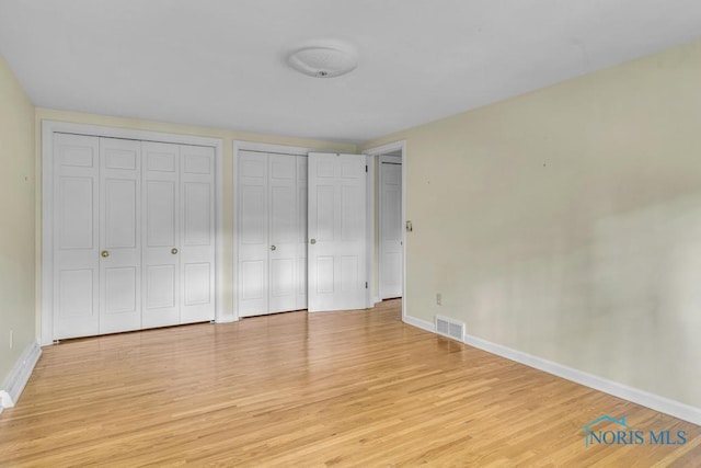 3432 Corey Rd, Toledo, OH 43615 - unfurnished bedroom featuring two closets and light wood-style flooring