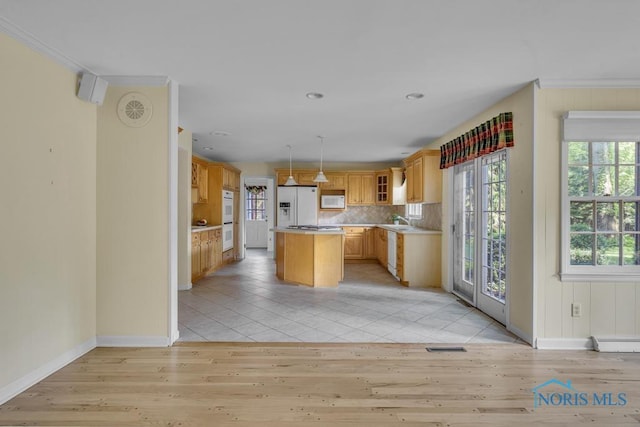 3432 Corey Rd, Toledo, OH 43615 - kitchen featuring white appliances, light wood-type flooring, a center island, decorative backsplash, and light countertops