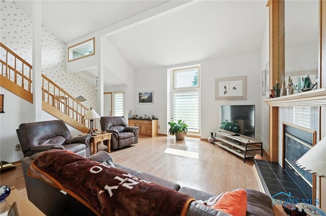 1780 Lexington Dr, Perrysburg, OH 43551 - living area featuring stairway, wood finished floors, a tiled fireplace, and high vaulted ceiling