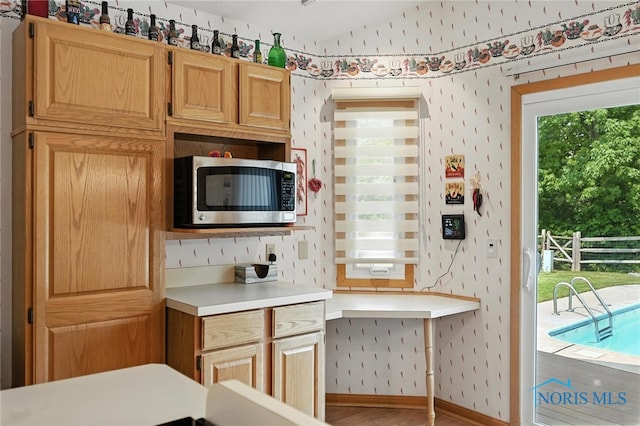 1780 Lexington Dr, Perrysburg, OH 43551 - kitchen with stainless steel microwave, light countertops, healthy amount of natural light, lofted ceiling, and wallpapered walls