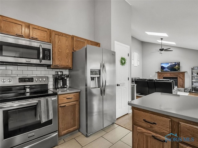 5425 Tulane Ave, Toledo, OH 43611 - kitchen featuring stainless steel appliances, vaulted ceiling, backsplash, brown cabinetry, and ceiling fan