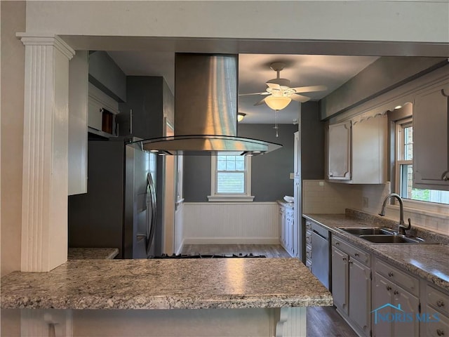 733 Mayfair Blvd, Toledo, OH 43612 - kitchen with island exhaust hood, appliances with stainless steel finishes, dark wood-style flooring, wainscoting, and ceiling fan