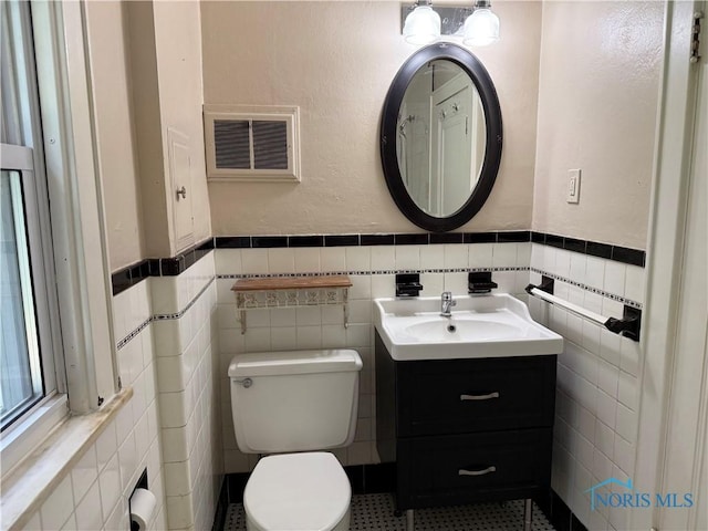 733 Mayfair Blvd, Toledo, OH 43612 - bathroom with tile walls, vanity, and a wainscoted wall
