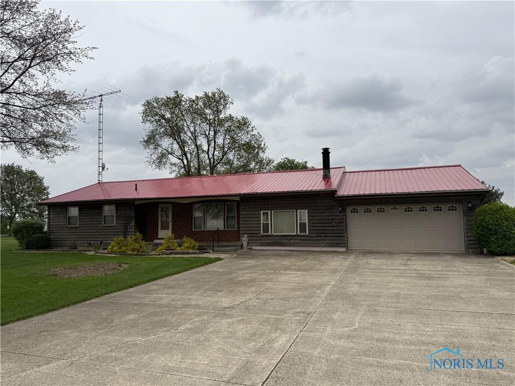 12401 County Highway 110, Upper Sandusky, OH 43351 - ranch-style home featuring concrete driveway, a front lawn, an attached garage, and a metal roof