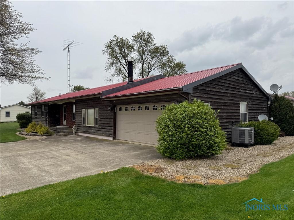 12401 County Highway 110, Upper Sandusky, OH 43351 - view of front facade with concrete driveway, a metal roof, and an attached garage