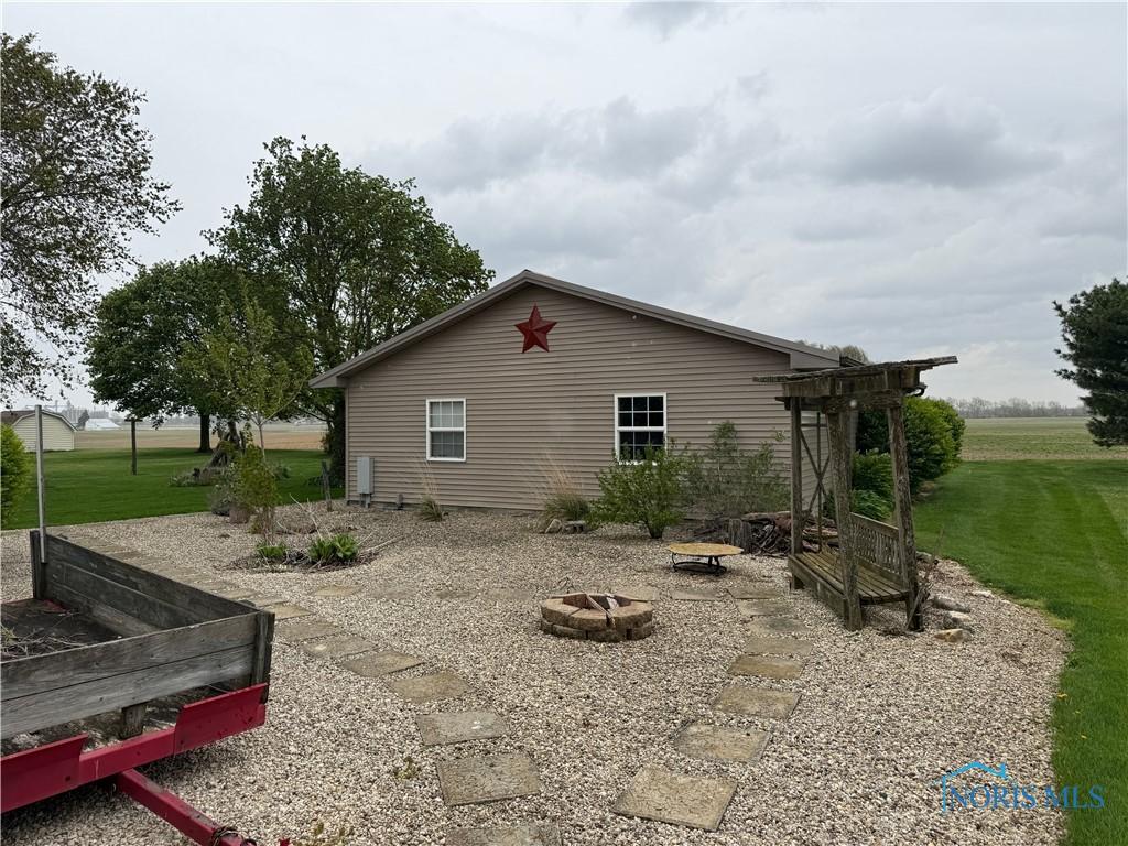 12401 County Highway 110, Upper Sandusky, OH 43351 - view of side of home with a fire pit and a yard