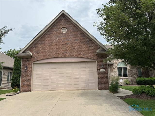 5346 Palisades Dr, Sylvania, OH 43560 - view of front of property featuring concrete driveway, brick siding, and a garage