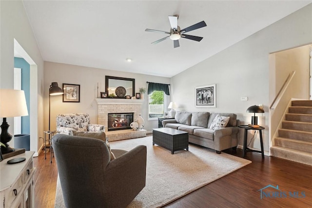 735 Hemlock St, Wauseon, OH 43567 - living room with vaulted ceiling, a ceiling fan, a fireplace, stairway, and wood finished floors