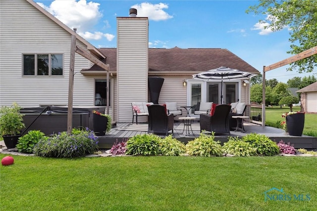 735 Hemlock St, Wauseon, OH 43567 - back of property with a deck, a hot tub, and a lawn