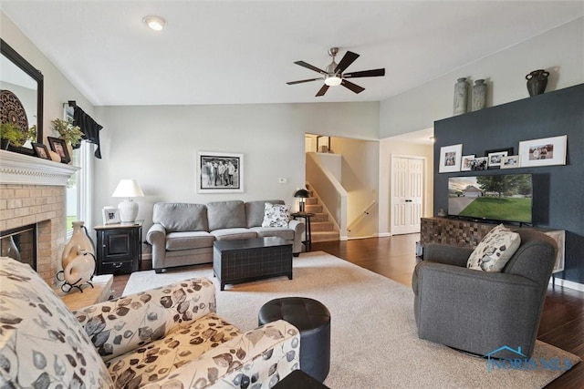 735 Hemlock St, Wauseon, OH 43567 - living area with wood finished floors, ceiling fan, lofted ceiling, stairs, and a brick fireplace