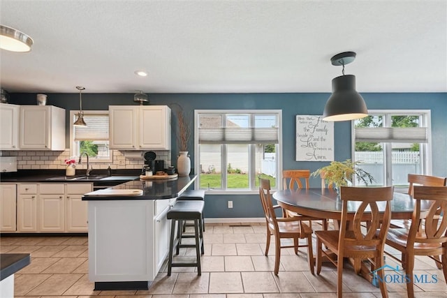 735 Hemlock St, Wauseon, OH 43567 - kitchen featuring plenty of natural light, dark countertops, tasteful backsplash, hanging light fixtures, and recessed lighting
