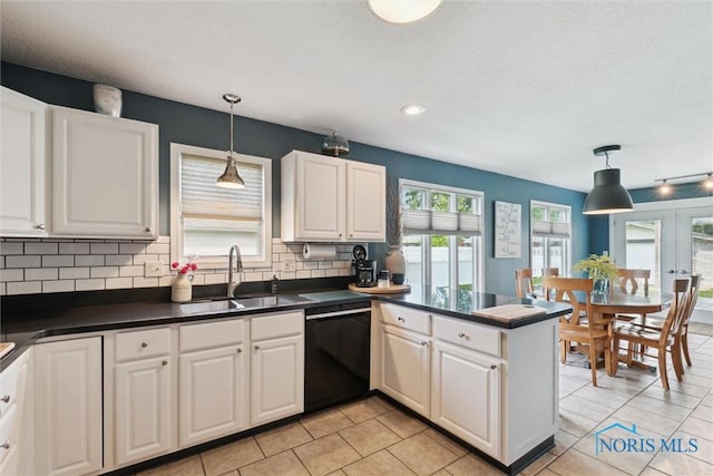 735 Hemlock St, Wauseon, OH 43567 - kitchen featuring black dishwasher, dark countertops, decorative backsplash, white cabinetry, and a peninsula