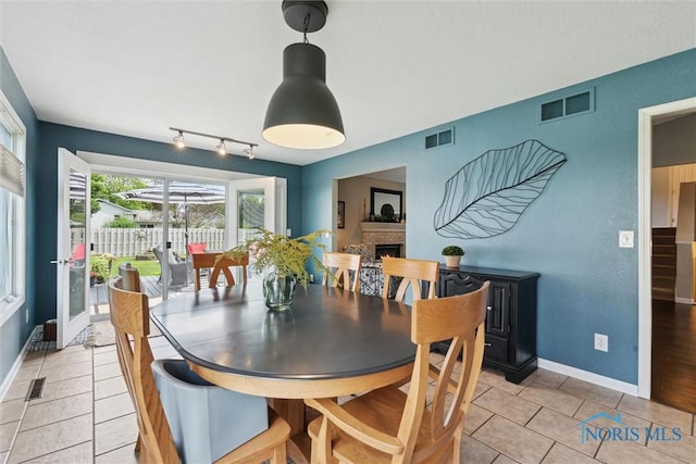 735 Hemlock St, Wauseon, OH 43567 - dining room with a fireplace, light tile patterned floors, and track lighting