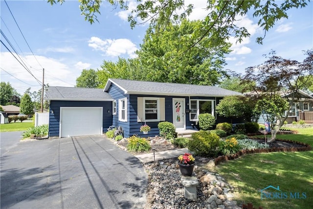 1118 5th St, Findlay, OH 45840 - ranch-style home featuring asphalt driveway, a front yard, an attached garage, and covered porch