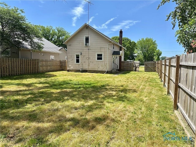 228 Harris St, Elmore, OH 43416 - rear view of house with a fenced backyard and a chimney