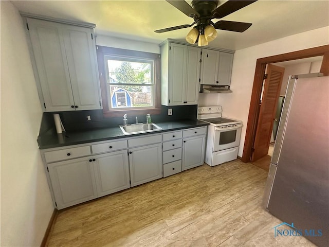 228 Harris St, Elmore, OH 43416 - kitchen with electric range, freestanding refrigerator, dark countertops, under cabinet range hood, and a ceiling fan