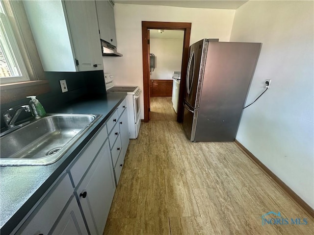 228 Harris St, Elmore, OH 43416 - kitchen featuring electric range, freestanding refrigerator, under cabinet range hood, dark countertops, and light wood finished floors