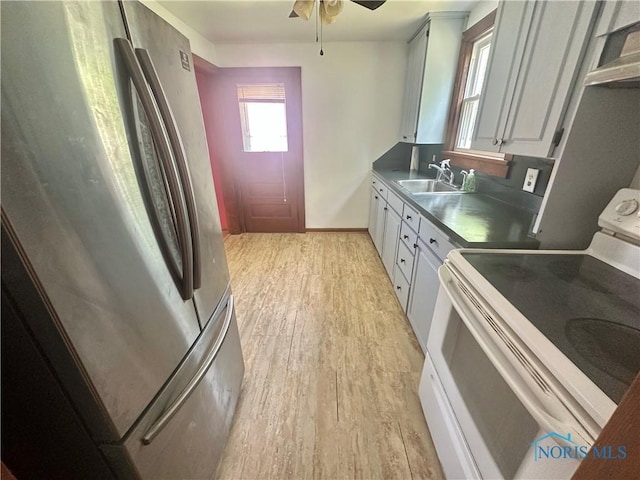 228 Harris St, Elmore, OH 43416 - kitchen with freestanding refrigerator, white electric range, light wood-type flooring, a ceiling fan, and white cabinets