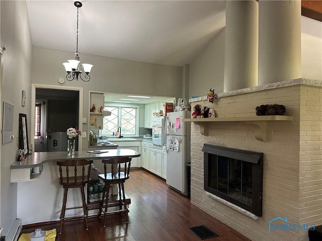 101 Maplewood Dr, Pandora, OH 45877 - dining space with dark wood-style flooring, a fireplace, a chandelier, and baseboard heating