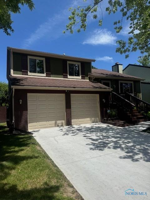 4504 Cherry Creek Ln, Toledo, OH 43615 - view of front of property with a garage, driveway, brick siding, and a chimney