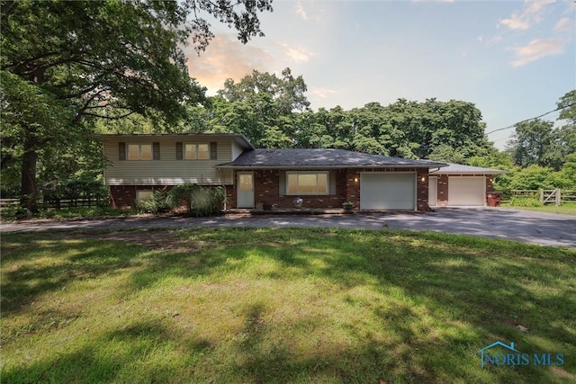 7948 Holstein Rd, Toledo, OH 43617 - split level home featuring a garage, driveway, and brick siding