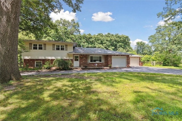 7948 Holstein Rd, Toledo, OH 43617 - split level home with asphalt driveway, brick siding, a front yard, and an attached garage