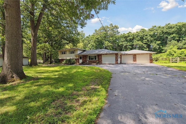 7948 Holstein Rd, Toledo, OH 43617 - split level home featuring a garage, brick siding, and driveway