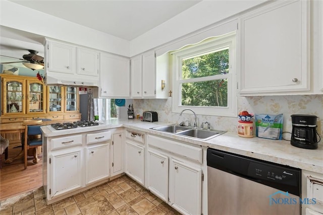 7948 Holstein Rd, Toledo, OH 43617 - kitchen with dishwasher, light countertops, white cabinets, ceiling fan, and gas stovetop