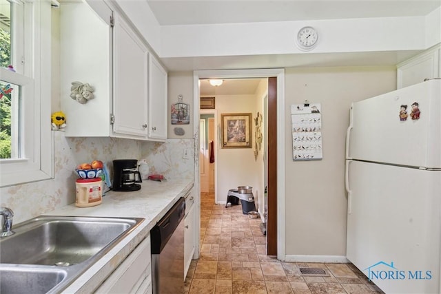 7948 Holstein Rd, Toledo, OH 43617 - kitchen featuring freestanding refrigerator, stainless steel dishwasher, white cabinets, and light countertops