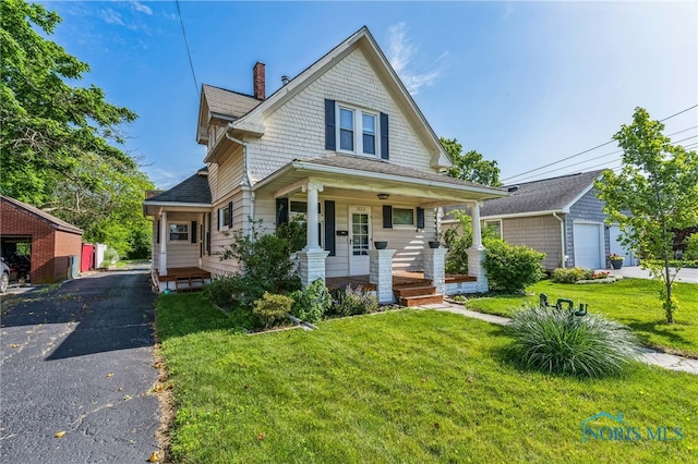 1022 E Sandusky St, Findlay, OH 45840 - victorian house with an outbuilding, covered porch, a chimney, and a front yard