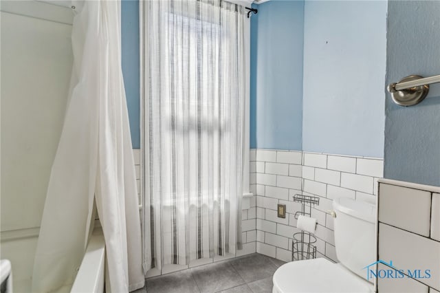1022 E Sandusky St, Findlay, OH 45840 - full bathroom featuring tile walls, tile patterned flooring, shower / bath combo with shower curtain, and wainscoting