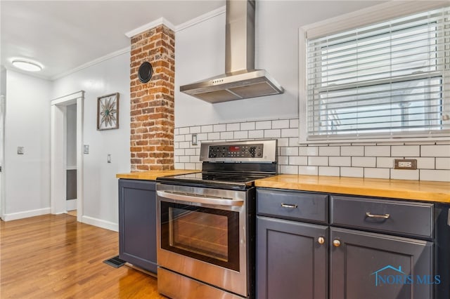 1022 E Sandusky St, Findlay, OH 45840 - kitchen featuring wall chimney exhaust hood, electric stove, butcher block countertops, tasteful backsplash, and ornamental molding