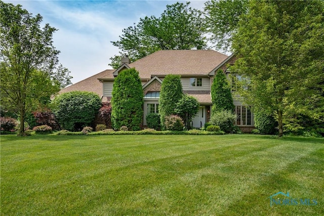 5301 River Oaks Ct, Sylvania, OH 43560 - view of front of home featuring a front yard, a chimney, and brick siding